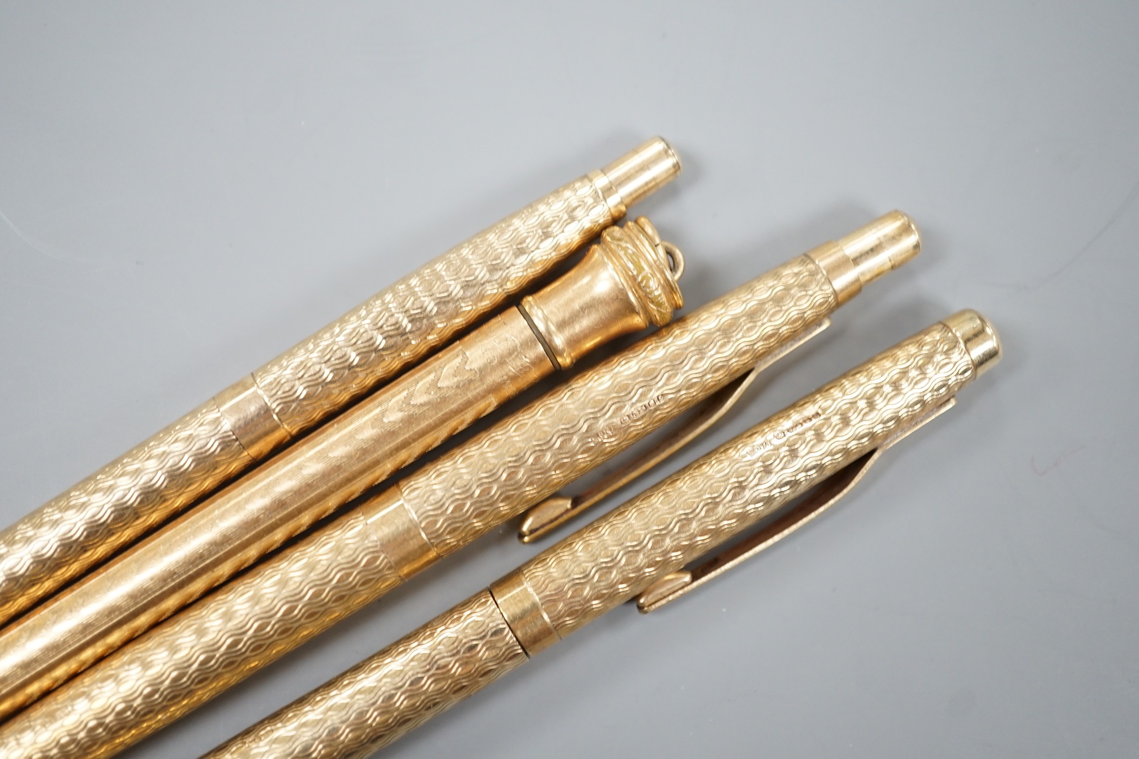 Three 9ct gold case ballpoint pens and a gold filled pen.